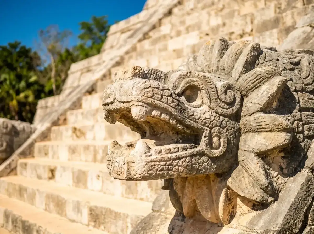 Detalle de la cabeza de serpiente emplumada tallada en piedra al pie de la escalinata norte de El Castillo en Chichén Itzá.
