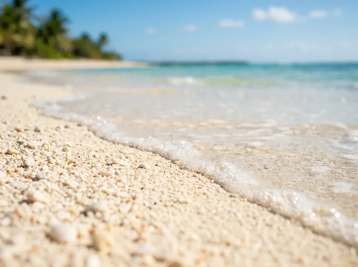 Primer plano de arena blanca fina y agua turquesa en una playa de la Zona Hotelera de Cancún.
